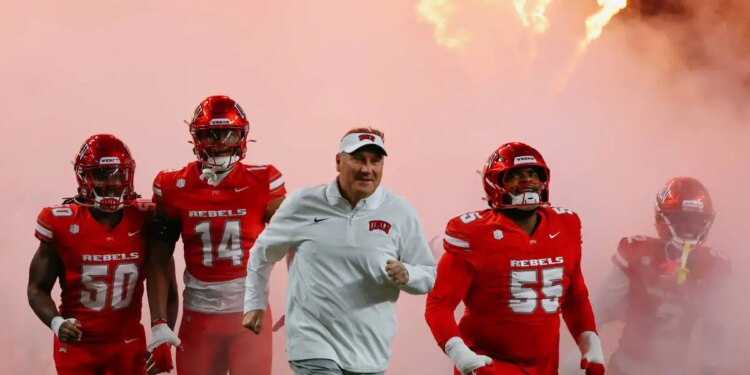 UNLV head coach Dan Mullen runs out with his team before the first half of the Ninth Island Sho ...